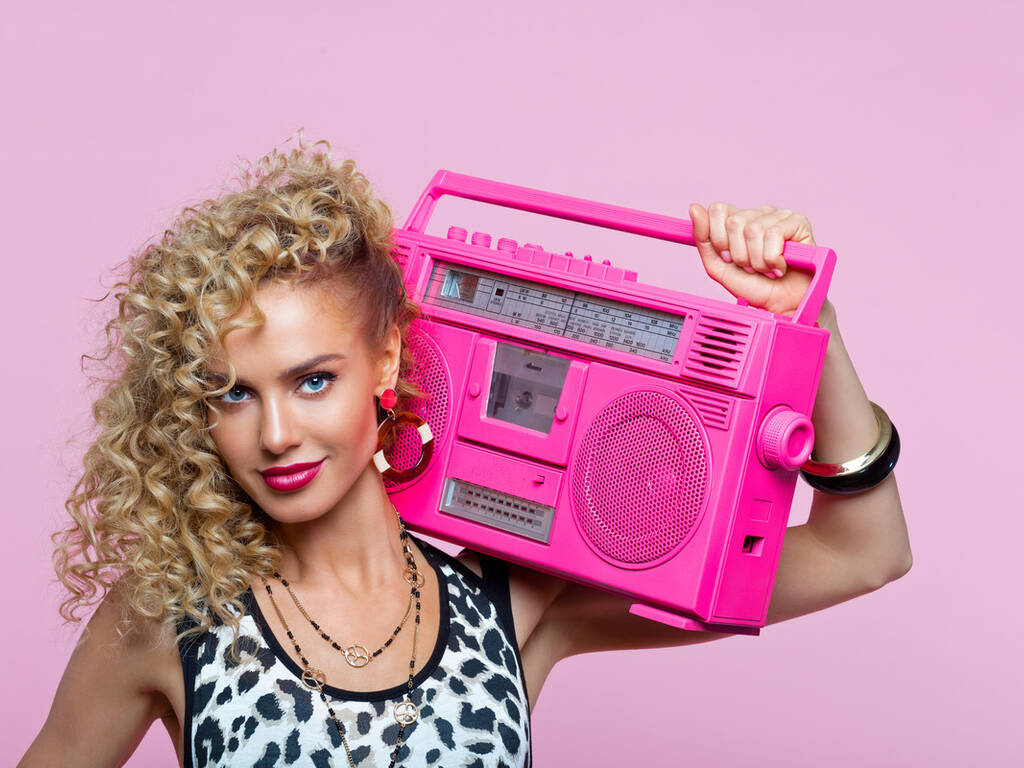 A stock image of an 80s woman carrying a boom box