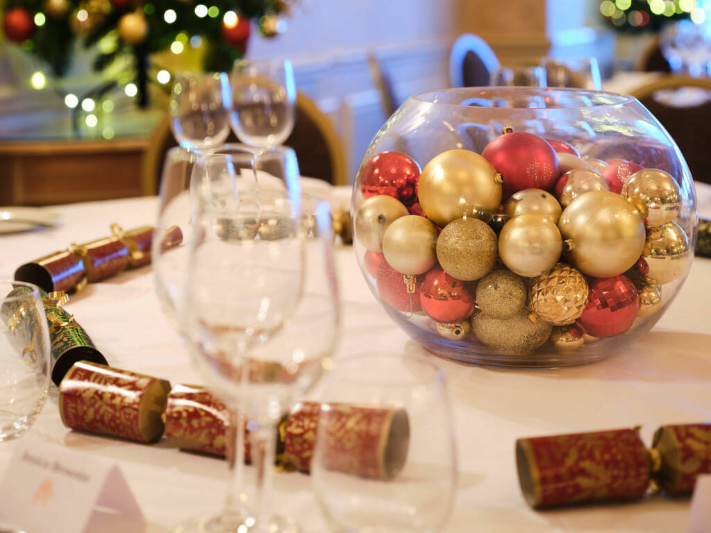 Christmas decorations including a christmas tree, christmas crackers and baubles in the Ballroom at Rowton Hall Hotel in Chester