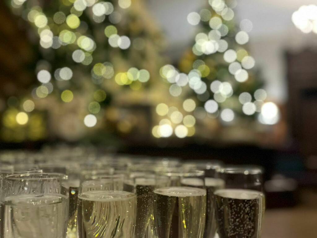 Prosecco glasses and blurred Christmas tree in background