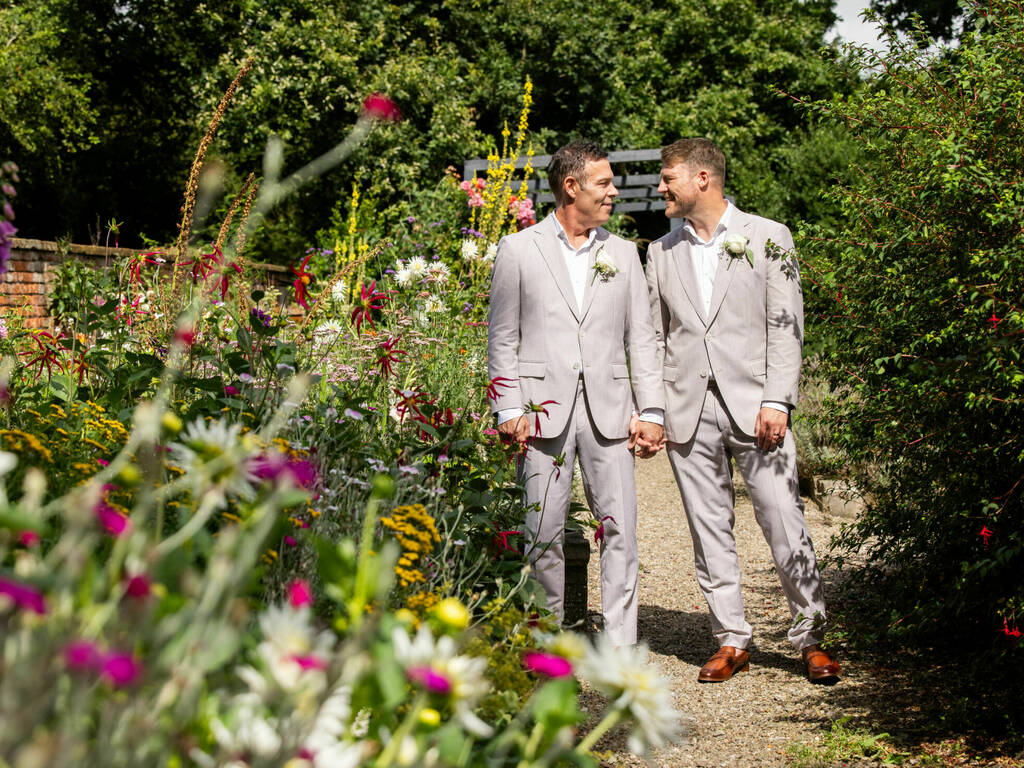 Grooms in the blooming gardens on their wedding day at Rowton Hall Hotel