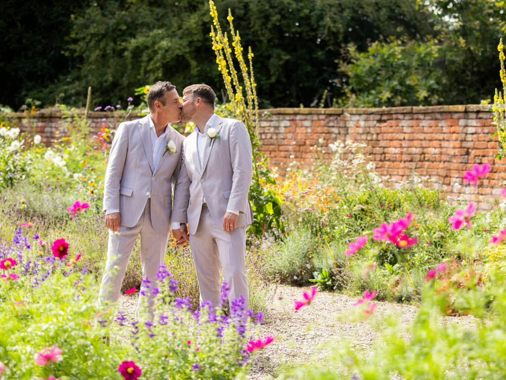 Grooms on their wedding day amongst the flowers in the walled garden