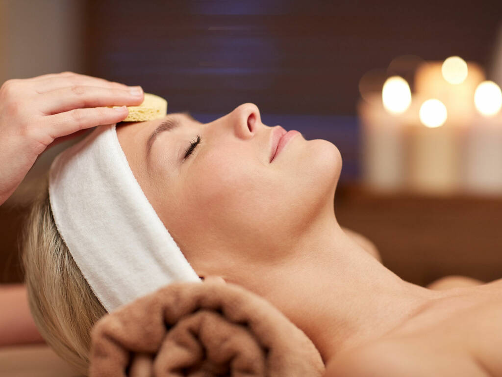 Lady having a facial with candles in background